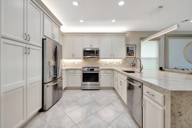 kitchen with visible vents, decorative backsplash, appliances with stainless steel finishes, a sink, and a peninsula