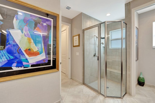 bathroom featuring a stall shower, baseboards, visible vents, and tile patterned floors