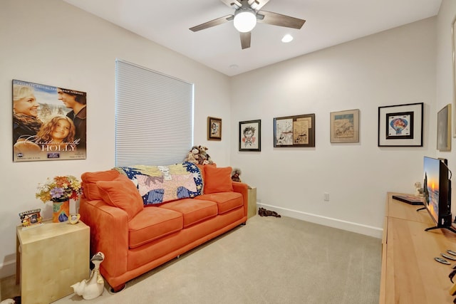 carpeted living room featuring baseboards and a ceiling fan