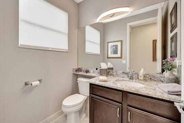 bathroom featuring toilet, tile patterned floors, baseboards, and vanity