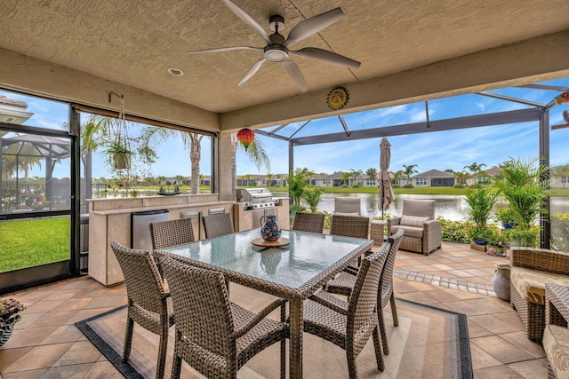 sunroom / solarium with a water view and a ceiling fan