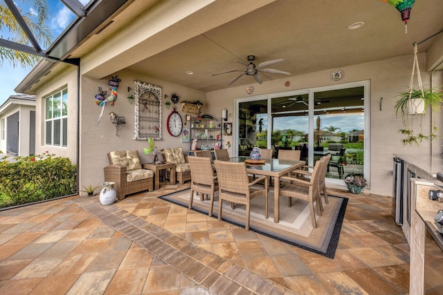 view of patio / terrace featuring outdoor dining space, a lanai, outdoor lounge area, and ceiling fan