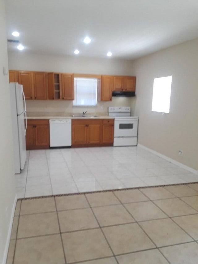 kitchen with sink, light tile patterned floors, and white appliances