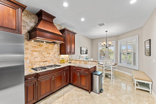 kitchen with decorative light fixtures, decorative backsplash, custom exhaust hood, kitchen peninsula, and stainless steel appliances