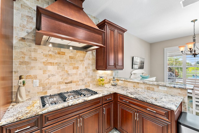 kitchen with pendant lighting, premium range hood, tasteful backsplash, stainless steel gas cooktop, and kitchen peninsula