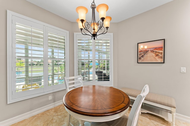 dining room with light tile patterned flooring and a notable chandelier