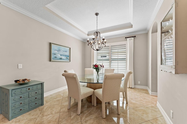 tiled dining room featuring crown molding, a tray ceiling, a textured ceiling, and a notable chandelier