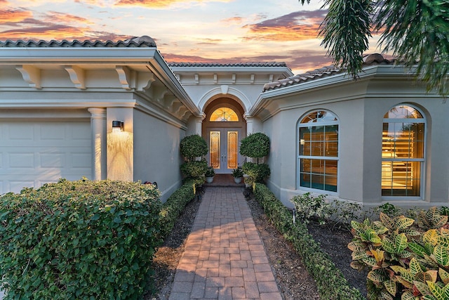 exterior entry at dusk with a garage