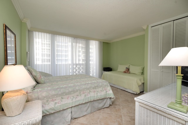 bedroom featuring a closet, crown molding, and light tile patterned flooring