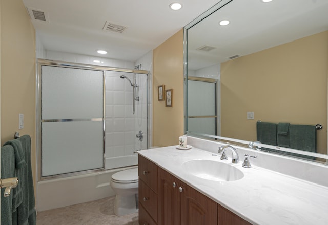 bathroom with toilet, shower / bath combination with glass door, vanity, and visible vents