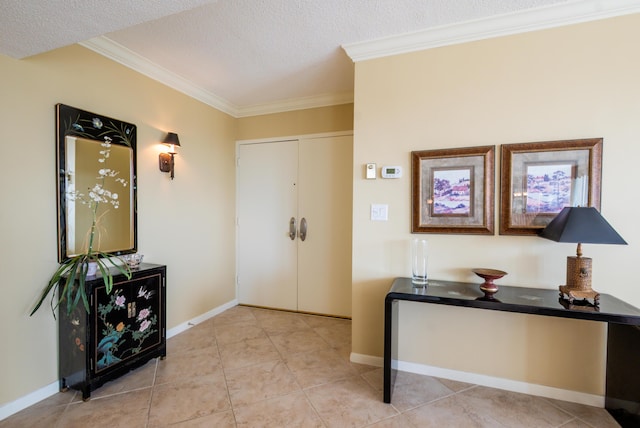 foyer featuring a textured ceiling, ornamental molding, and baseboards