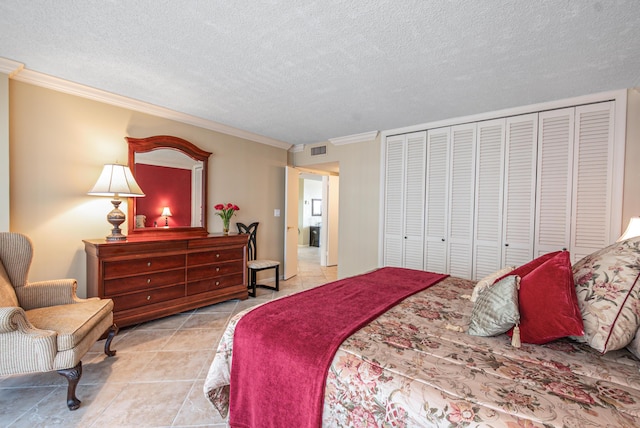 bedroom with light tile patterned floors, visible vents, crown molding, a textured ceiling, and a closet