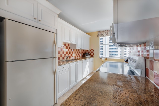 kitchen with tasteful backsplash, white appliances, white cabinetry, and a sink