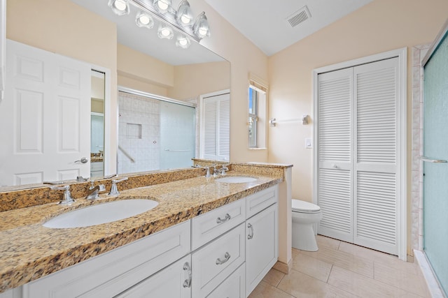 bathroom featuring lofted ceiling, a shower with door, vanity, tile patterned floors, and toilet