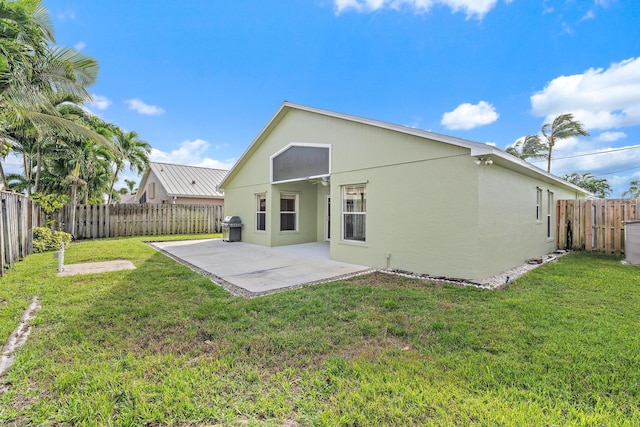 back of property featuring a lawn and a patio