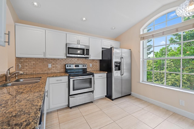 kitchen with sink, tasteful backsplash, appliances with stainless steel finishes, dark stone counters, and white cabinets