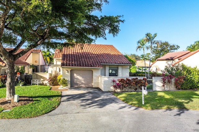 mediterranean / spanish-style home featuring a garage and a front yard