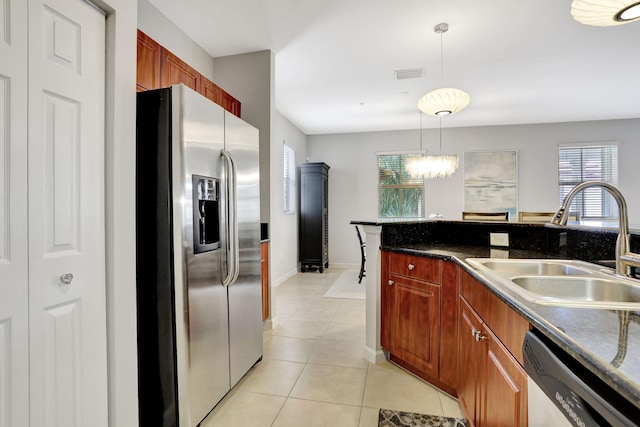 kitchen featuring sink, light tile patterned floors, hanging light fixtures, and appliances with stainless steel finishes