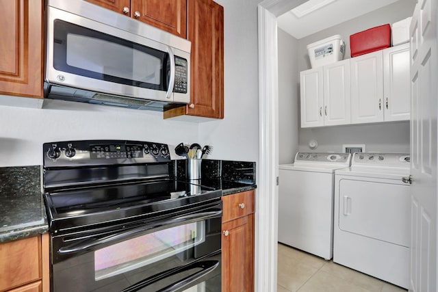 kitchen with double oven range, light tile patterned floors, and washer and dryer