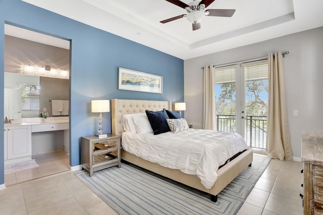 tiled bedroom with ensuite bath, ceiling fan, french doors, access to outside, and a raised ceiling