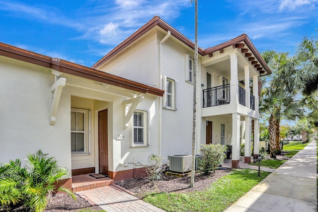 view of front of property with a balcony and central AC unit