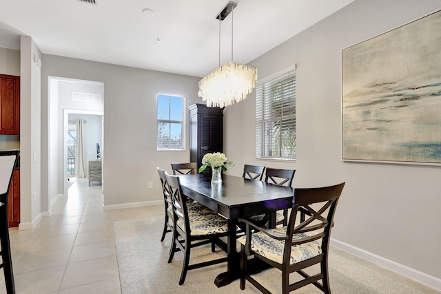 dining area featuring an inviting chandelier and light tile patterned floors