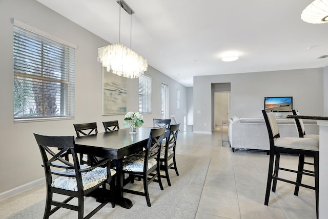 dining area with light tile patterned flooring and an inviting chandelier