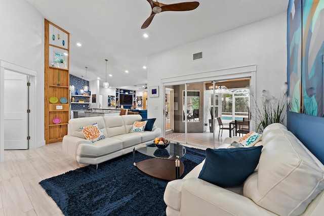 living room featuring ceiling fan, high vaulted ceiling, and light hardwood / wood-style floors