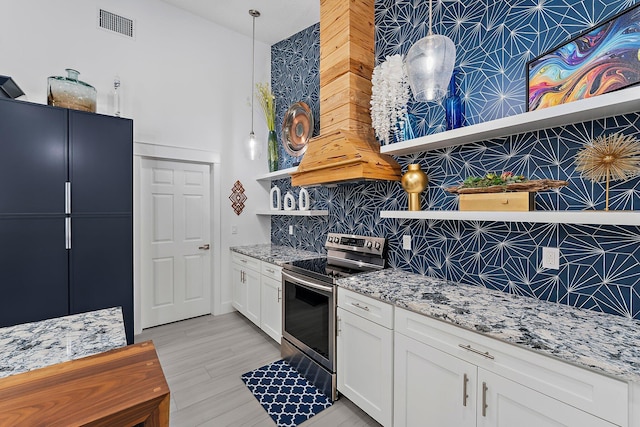 kitchen featuring stainless steel electric range oven, white cabinetry, decorative backsplash, hanging light fixtures, and light stone countertops