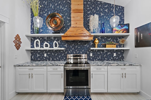 kitchen with backsplash, electric range, light stone countertops, white cabinets, and decorative light fixtures