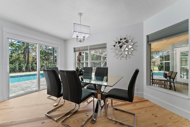 dining area featuring hardwood / wood-style floors, a chandelier, and a textured ceiling