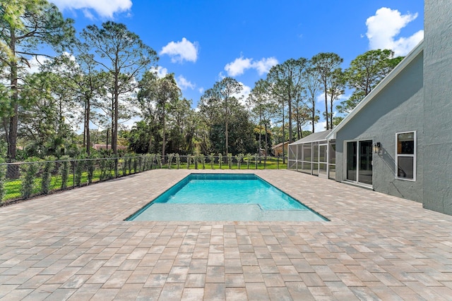 view of swimming pool featuring a patio area and glass enclosure