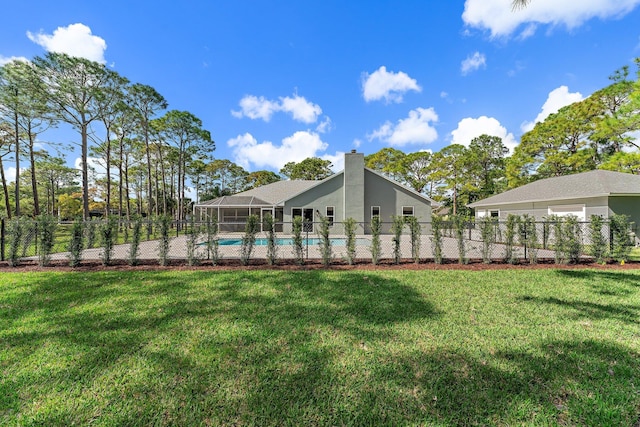 back of house with a fenced in pool, a yard, and glass enclosure