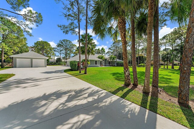 14450 69th Dr N, Palm Beach Gardens, FL 33418 - view of home's exterior featuring central air condition unit, a shingled roof, stucco siding, and a detached garage