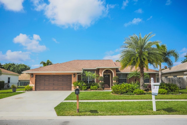 ranch-style house featuring a garage and a front lawn