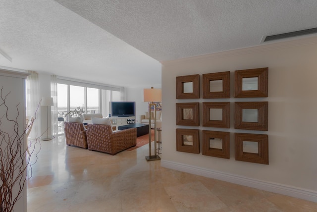 living area featuring a textured ceiling, visible vents, and baseboards