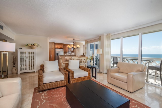 living area featuring visible vents, a water view, crown molding, a textured ceiling, and a notable chandelier