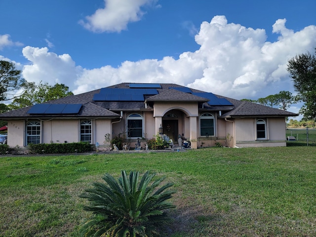 view of front facade with a front lawn and solar panels