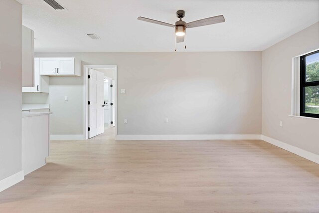 spare room with ceiling fan and light wood-type flooring