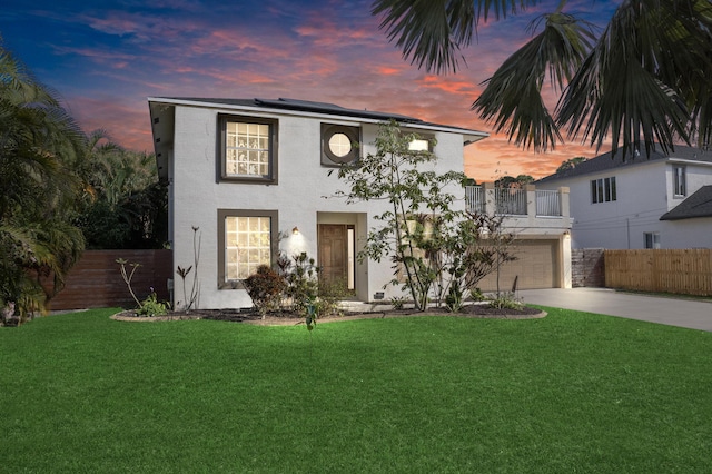 view of front of house with a garage, a lawn, and solar panels