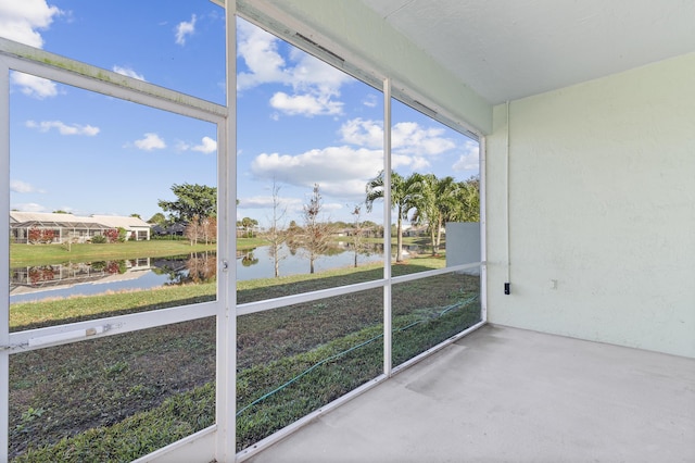 unfurnished sunroom featuring a water view