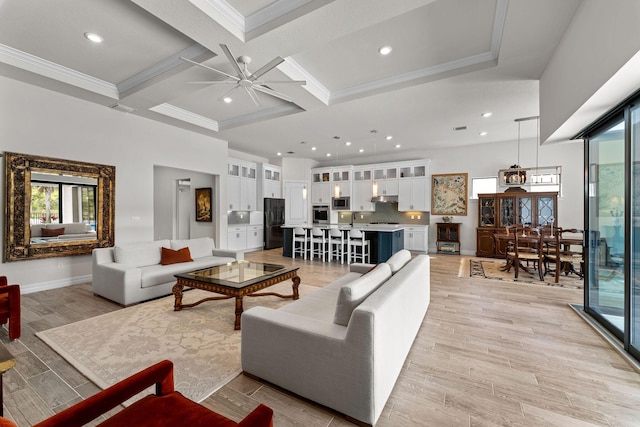 living area featuring ceiling fan, beamed ceiling, ornamental molding, light wood-style floors, and coffered ceiling