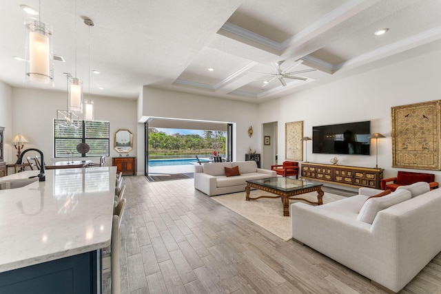 living room with beam ceiling, a high ceiling, wood finished floors, coffered ceiling, and a ceiling fan