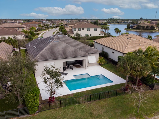 view of pool with a patio, a fenced in pool, a fenced backyard, a lawn, and a residential view