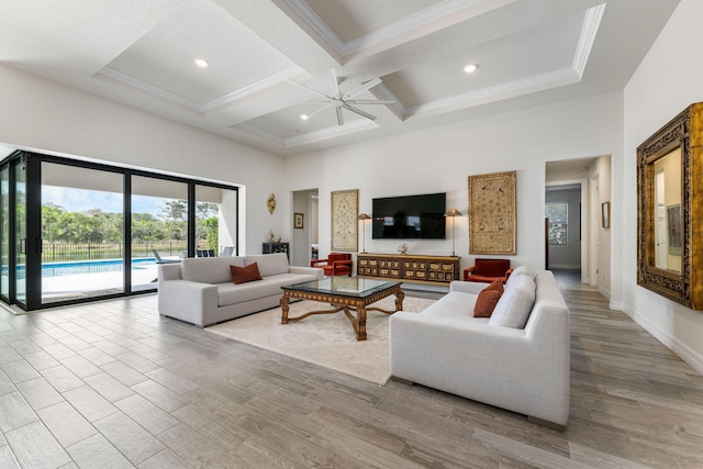 living room with wood finished floors, coffered ceiling, ornamental molding, ceiling fan, and a towering ceiling