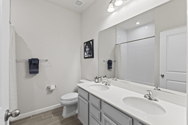 bathroom featuring vanity, toilet, and curtained shower