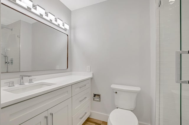 bathroom with a shower with door, vanity, hardwood / wood-style flooring, and toilet