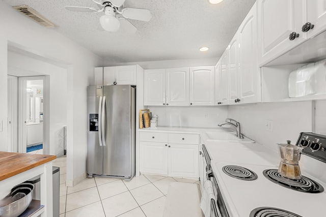 kitchen featuring sink, range with electric cooktop, stainless steel refrigerator with ice dispenser, white cabinets, and light tile patterned flooring