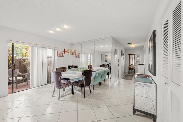 dining area with plenty of natural light, a textured ceiling, and light tile patterned floors