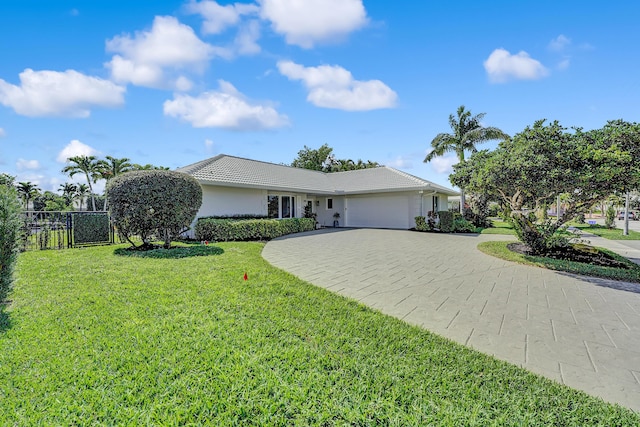 ranch-style house featuring a garage and a front lawn